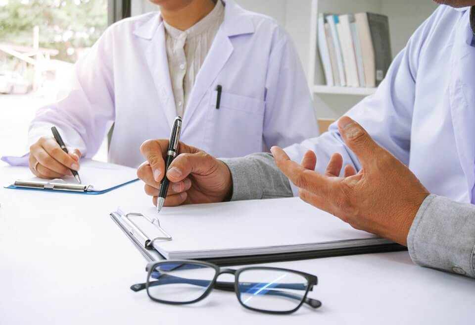 Cropped image of two medical professionals reviewing plans of care for in-home patients.